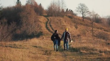 Açık havada hiking el ele tutuşarak aşk çift. Yürüyüş yapan adam ve kadın trekking iz içinde sırt çantaları ile günbatımında dağlarda yürüyüş