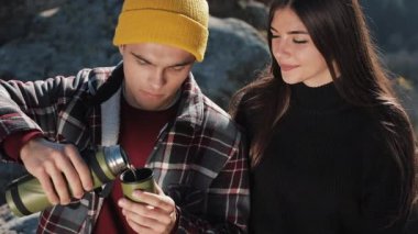 Termos dağ zemin üzerine birkaç aşk içecek çay üzerinden bir kupa. Taşlar üzerinde oturan ve güzel doğa üzerinde seyir turistler. Turizm, dinlenme, tatil, Doğa, zam kavramı