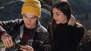 Termos dağ zemin üzerine birkaç aşk içecek çay üzerinden bir kupa. Taşlar üzerinde oturan ve güzel doğa üzerinde seyir turistler. Turizm, dinlenme, tatil, Doğa, zam kavramı