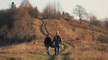 Açık havada hiking el ele tutuşarak aşk çift. Yürüyüş yapan adam ve kadın trekking iz içinde sırt çantaları ile günbatımında dağlarda yürüyüş.