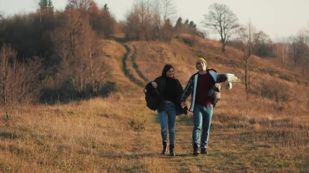 屋外のハイキングの手を保持している愛のカップル。ハイカーの男とトレッキングと歩いている女性トレイルでバックパック夕暮れ山 — ストック動画