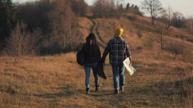 Açık havada hiking el ele tutuşarak aşk çift. Yürüyüş yapan adam ve kadın trekking iz içinde sırt çantaları ile günbatımında dağlarda yürüyüş