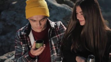 Termos dağ zemin üzerine birkaç aşk içecek çay üzerinden bir kupa. Taşlar üzerinde oturan ve güzel doğa üzerinde seyir turistler. Turizm, dinlenme, tatil, Doğa, zam kavramı