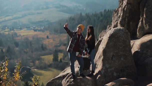 Jeune couple amoureux debout sur les rochers et prenant un portrait selfie. Homme et femme visitant la célèbre attraction touristique — Video