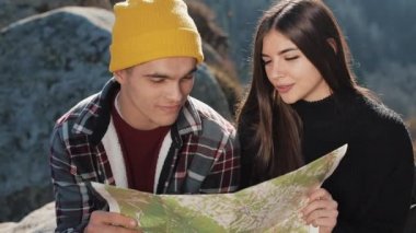 Dağlara yolculuk. Güzel çift aşık kayanın üzerinde oturur ve bir harita öğrenir. Birbirimize karşı gülen ve having fun konuşuyorlar