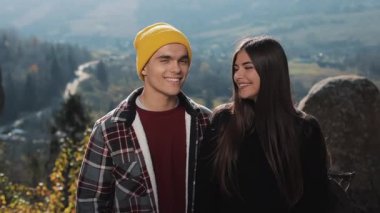 Genç mutlu turist birkaç güzel dağlarda kayalar üzerinde duruyor. Onlar kamera ve gülümseme bak