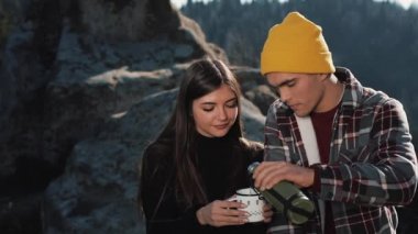 Termos dağ zemin üzerine birkaç aşk içecek çay üzerinden bir kupa. Taşlar üzerinde oturan ve güzel doğa üzerinde seyir turistler. Turizm, dinlenme, tatil, Doğa, zam kavramı