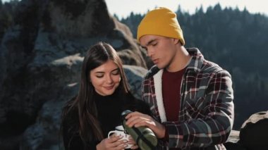 Termos dağ zemin üzerine birkaç aşk içecek çay üzerinden bir kupa. Taşlar üzerinde oturan ve güzel doğa üzerinde seyir turistler. Turizm, dinlenme, tatil, Doğa, zam kavramı