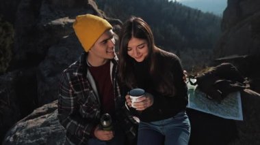 Termos dağ zemin üzerine birkaç aşk içecek çay üzerinden bir kupa. Taşlar üzerinde oturan ve güzel doğa üzerinde seyir turistler. Turizm, dinlenme, tatil, Doğa, zam kavramı