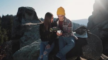 Termos dağ zemin üzerine birkaç aşk içecek çay üzerinden bir kupa. Taşlar üzerinde oturan ve güzel doğa üzerinde seyir turistler. Turizm, dinlenme, tatil, Doğa, zam kavramı