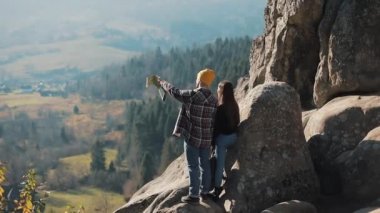 Genç turist iki sonra kayalar üzerinde duran seviyorum ve güzel manzaranın tadını çıkarın. Erkek ve kadın ünlü turistik ziyaret