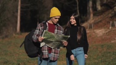 Uzun yürüyüşe çıkan kimse iki harita ile ormandaki hiking. Manzarayı güzel dağ manzarası içinde romantik yürüyüş yapanlar. Ağır çekim
