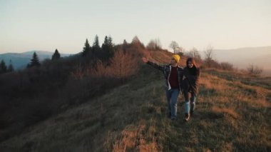 İki aşık açık havada hiking. Yürüyüş yapan adam ve kadın trekking iz içinde sırt çantaları ile günbatımında dağlarda yürüyüş