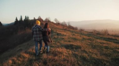 İki aşık açık havada hiking. Yürüyüş yapan adam ve kadın trekking iz içinde sırt çantaları ile günbatımında dağlarda yürüyüş