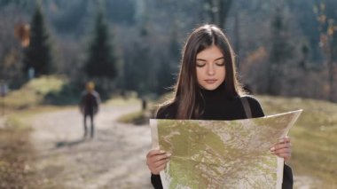 Dağlara yolculuk. Genç kadın ormanda eski harita ayakta tutar. Güzel dağlarda turistik seyahatler