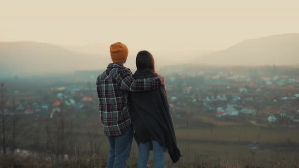 Ein junges verliebtes Paar, das sich auf den Horizont und die Berge freut. zurück — Stockvideo