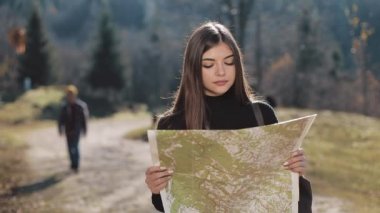 Dağlara yolculuk. Genç kadın ormanda eski harita ayakta tutar. Güzel dağlarda turistik seyahatler