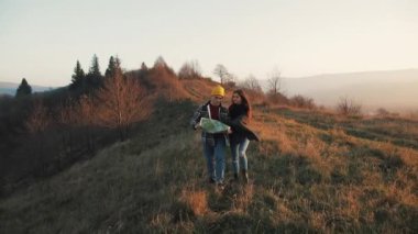 İki aşık açık havada hiking. Yürüyüş yapan adam ve kadın trekking harita ile iz içinde sırt çantaları ile günbatımında dağlarda yürüyüş
