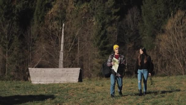 Uzun yürüyüşe çıkan kimse iki harita ile ormandaki hiking. Manzarayı güzel dağ manzarası içinde romantik yürüyüş yapanlar. Ağır çekim — Stok video