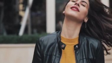 Sokakta yürürken, seyir ve kameraya poz mutlu genç kadın. Güzel kız dans hareket. Ağır çekim