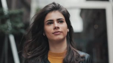 Deri ceketli genç ve güzel kadın iş merkezine yakın yürüyor. Kız saç güzelliği burada giderir.