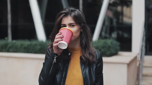 Retrato de una joven morena tomando café mirando a la cámara. Riendo retrato alegre de la mujer de negocios exitosa profesional ejecutiva — Vídeos de Stock