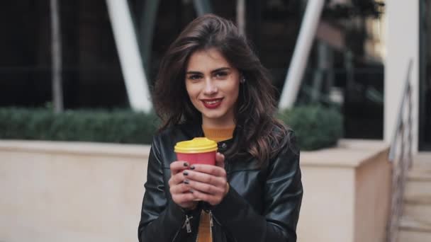 Portrét mladé ženy bruneta s kávou, při pohledu do kamery. Směje se veselý portrét úspěšných obchodních žena výkonné Professional — Stock video
