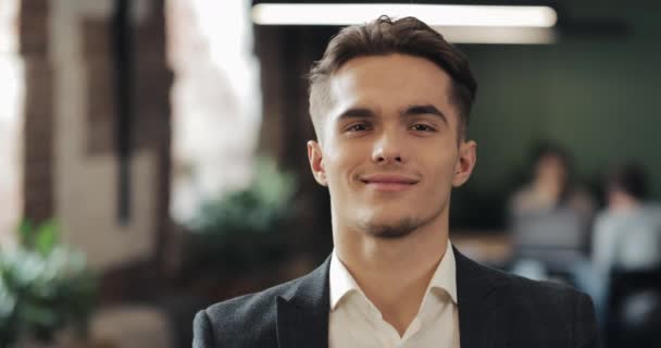 Portrait of young successful businessman at busy office. Handsome male employee looking at camera and smiling. Business, Finance, Founder, Success Concept — Stock Video