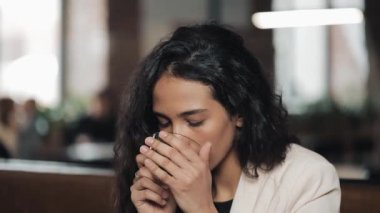 Gülümseyen ve kameraya bakarak çay içme ve kafede, rahatlatıcı mutlu kız