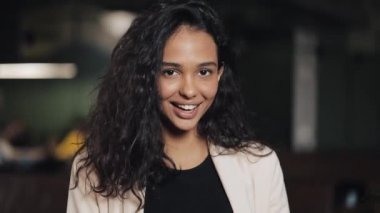 Çekici genç kadın sıcak kahve dükkanında mutlu hissediyorum gülümseyerek kameraya bakıyor. Yakın çekim