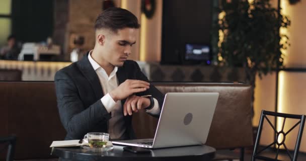 Jeune homme d'affaires travaillant dans un bureau moderne ou co-travaillant et utilisant la montre intelligente. Freelance parler à une smartwatch 4K UHD — Video