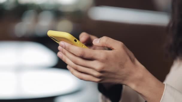 Vacker kvinna med smartphone i café. Flicka händer textning på smartphone. Närbild — Stockvideo