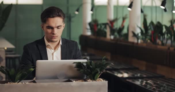 Młody Biznesmen Poważne Siedzący Przytulnej Kawiarni Pracy Laptopem Freelancer Lub — Wideo stockowe