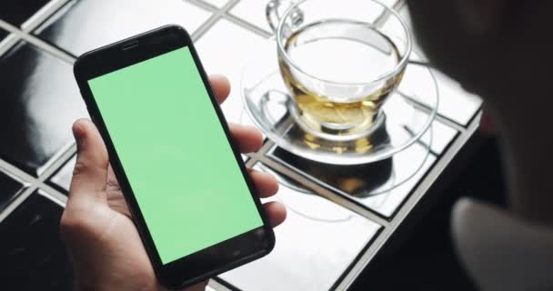 Joven hombre de negocios utilizar smarthpone con panel táctil de pantalla verde y el gesto de cerca en la cafetería. Tipo sosteniendo celular, tocando y desplazándose por las páginas de navegación y leer noticias — Vídeos de Stock