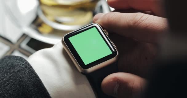 Gros plan des mains de l'homme d'affaires avec smartwatch écran vert chroma clé. Allumez, tapotez et faites défiler le mouvement. Café confortable en arrière-plan — Video