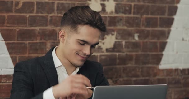 Jovem empresário trabalhando em escritório moderno ou co-trabalhando e usando relógio inteligente. Freelancer falando com um smartwatch 4K UHD — Vídeo de Stock