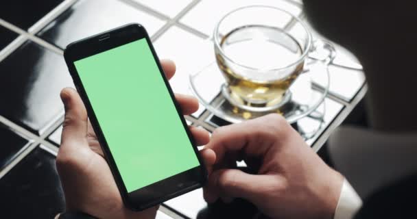 Joven hombre de negocios utilizar smarthpone con panel táctil de pantalla verde y el gesto de cerca en la cafetería. Tipo sosteniendo celular, tocando y desplazándose por las páginas de navegación y leer noticias — Vídeos de Stock