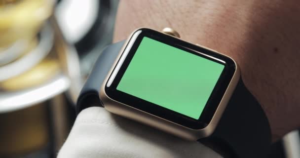 İş adamı elinde smartwatch yeşil ekran chroma anahtar ile kapatın. Arka planda rahat kafe — Stok video