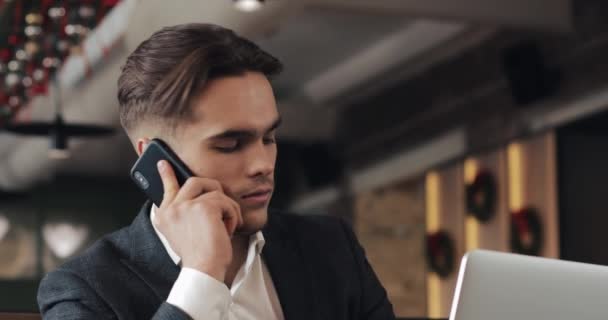Młody biznesmen praca w nowoczesnym biurze lub współ-pracy, mówi przez telefon i za pomocą inteligentnego watch. Biznesmenem, It, koncepcja Freelancer. 4k Uhd — Wideo stockowe