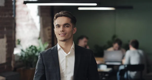 Genç başarılı bir işadamı meşgul ofis portre. Kameraya bakarak ve gülümseyen yakışıklı erkek çalışan. İş, finans, kurucusu, başarı kavramı