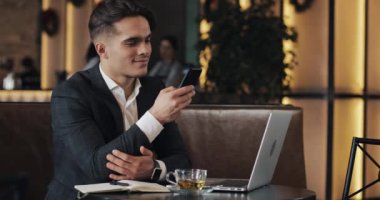 Genç işadamı kafede çalışıyor. Freelancer Smartphone ve dizüstü bilgisayar kullanarak. Başarılı iş, BT, Freelancer kavramı.
