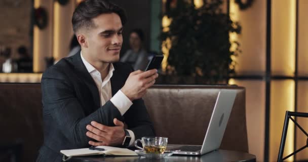 Young businessman working in cafe. Freelancer using smartphone and laptop. Successful busines, IT, Freelancer concept. — Stock Video