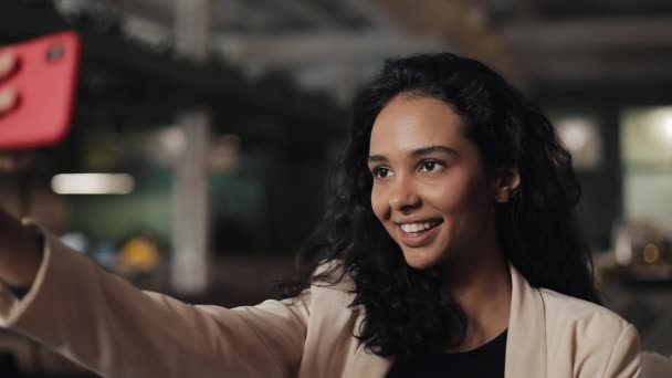 Стильна молода бізнес-леді сидить у кафе і приймає селфі зі своїм смартфоном — стокове відео