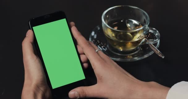 Молодая деловая женщина держит смартфон с зеленым экраном вблизи кафе — стоковое видео
