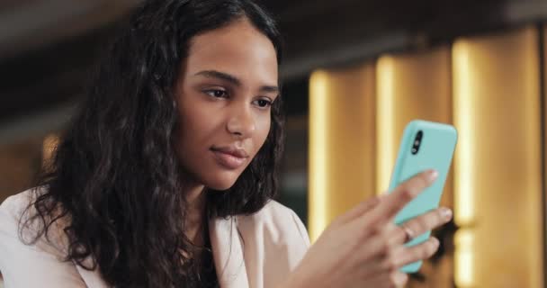 Young Zakenvrouw met behulp van mobiele telefoon op gezellige Coffee Shop. Ze surfen Online berichten en beantwoorden van teksten — Stockvideo