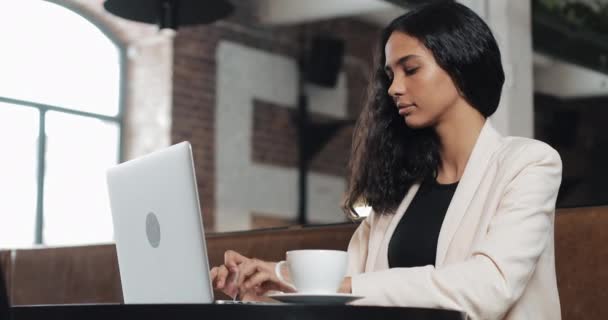 Jeune femme d'affaires finissant son travail sur ordinateur portable et détendue au bureau moderne — Video