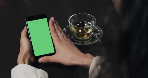 Jeune femme d'affaires utilisent smartphone avec écran vert. Vitre tactile sur écran vert smartphone noir. Utilisation du smartphone, tenant smartphone avec écran vert — Video