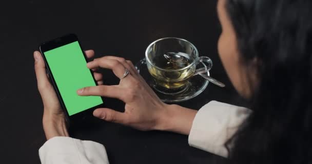 Jeune femme d'affaires utilisent smarthpone avec pavé tactile écran vert et geste de près dans le café. Fille tenant cellulaire, tapant et défilant par les pages de navigation et lire les nouvelles — Video