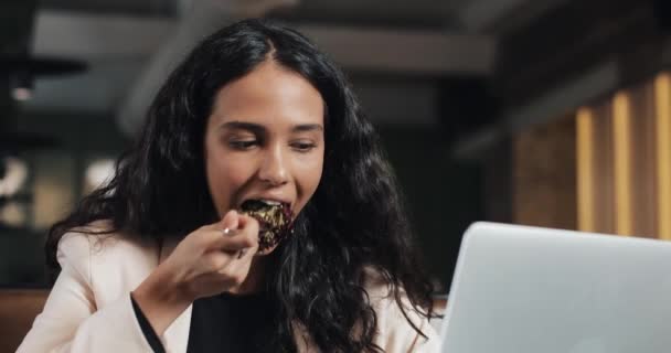 Bir dizüstü bilgisayar kafede oturan ve bir fincan çay ile akşam yemeği masada yemek bir iş kadını. Çalışma masası yemek — Stok video