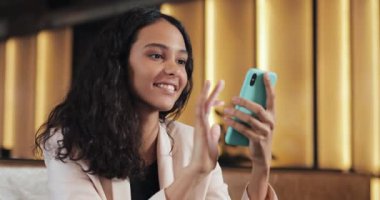 App akıllı kafe ve manifatura üstünde hareket eden telefon kullanan genç mutlu iş kadın. Cep telefonu ile pembe elbiseli güzel casual kadın profesyonel. Yakın çekim